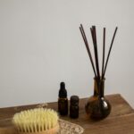 A minimalist display of aromatherapy bottles and a brush on a wooden table.