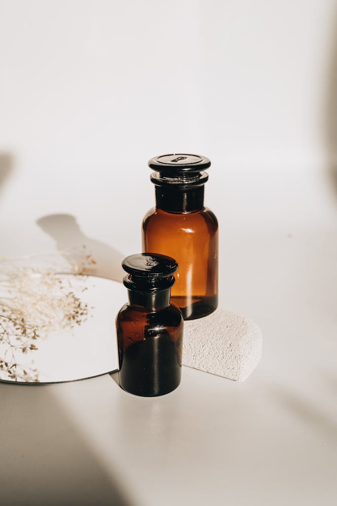 Aesthetic amber glass bottles on a white surface, perfect for skincare or product photography.
